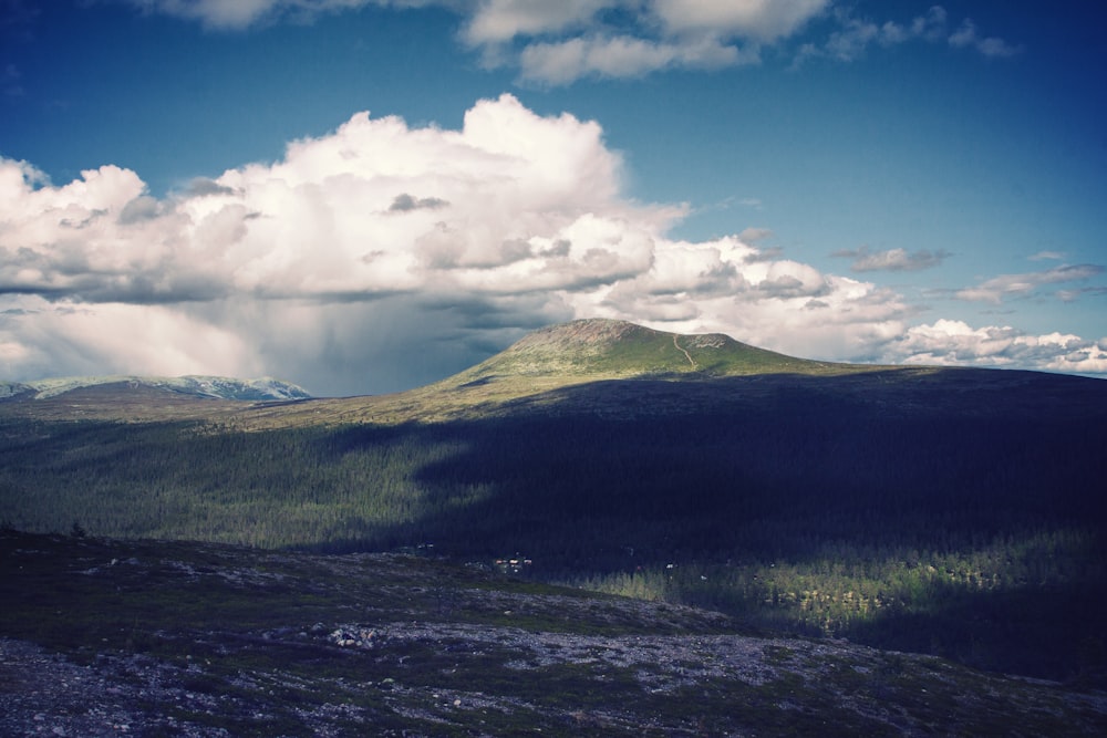 green mountain under white clouds during daytime