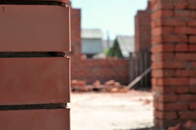 Close-up of a bricklayer carefully placing bricks on a residential building site managed by cig.