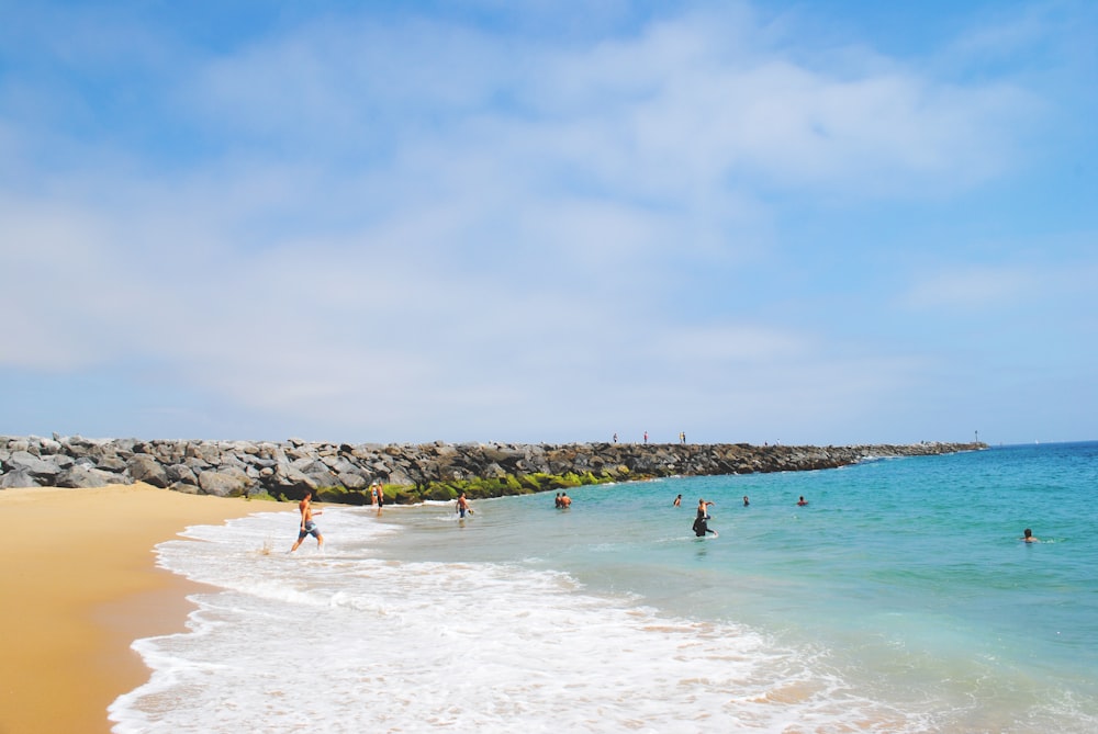 people swimming on beach