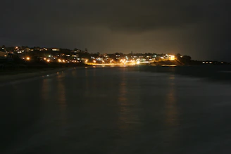 Nighttime shot of a lit terrace overlooking the calm Mazatlán coastline.