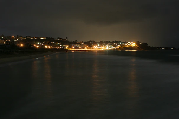 Nighttime shot of a lit terrace overlooking the calm Mazatlán coastline.