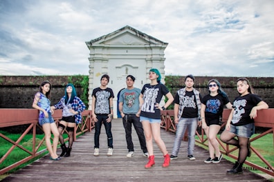 A group of diverse young adults showcasing fashionable outfits in an urban setting.