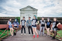 A group of diverse young adults showcasing their fashionable outfits in an urban environment.