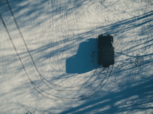 aerial photography of black SUV on dirt road at daytime