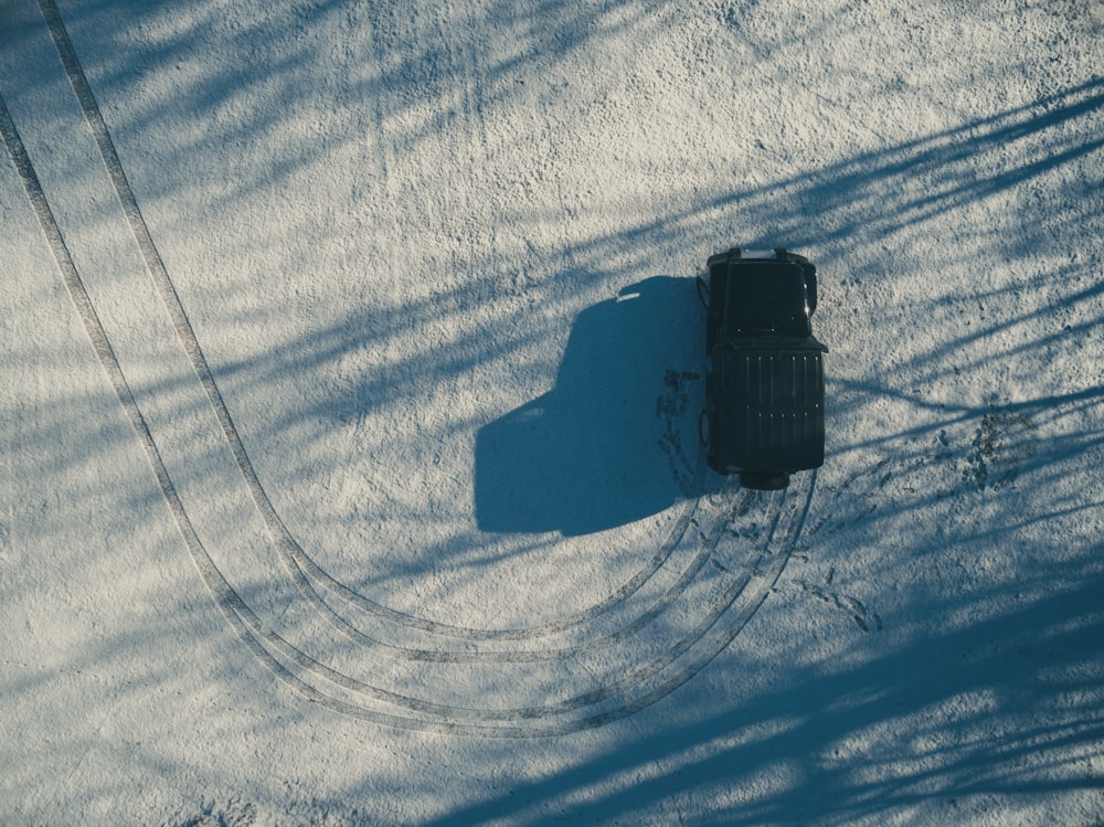 photographie aérienne d’un SUV noir sur un chemin de terre de jour