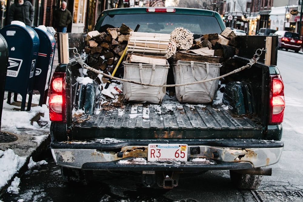 コンクリートの車道に駐車中に薪を積んだピックアップトラック