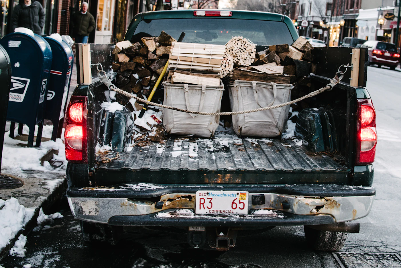 Pickup truck bed loaded with firewood and bins