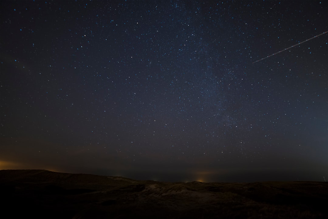 landscape photograph of meteor falling in the sky