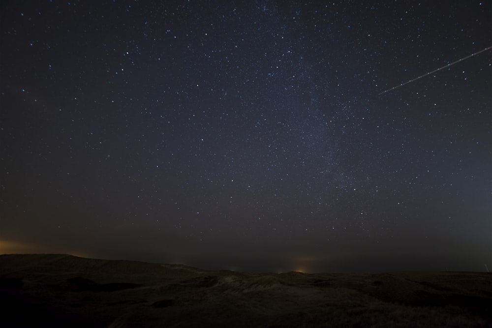 landscape photograph of meteor falling in the sky