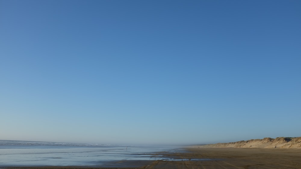 Plan d’eau et bord de mer gris sous ciel bleu