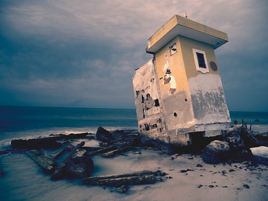 brown concrete house under gray clouds in Holbox Mexico