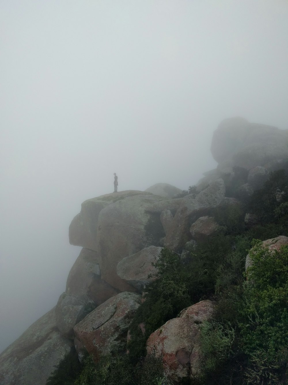 man standing at rock formation