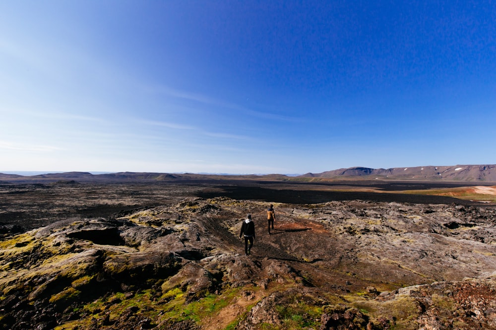 photo of two people standing on hilltop mountain