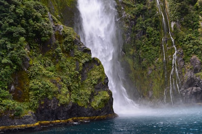 waterfall streaming through lake
