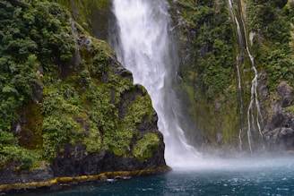 waterfall streaming through lake