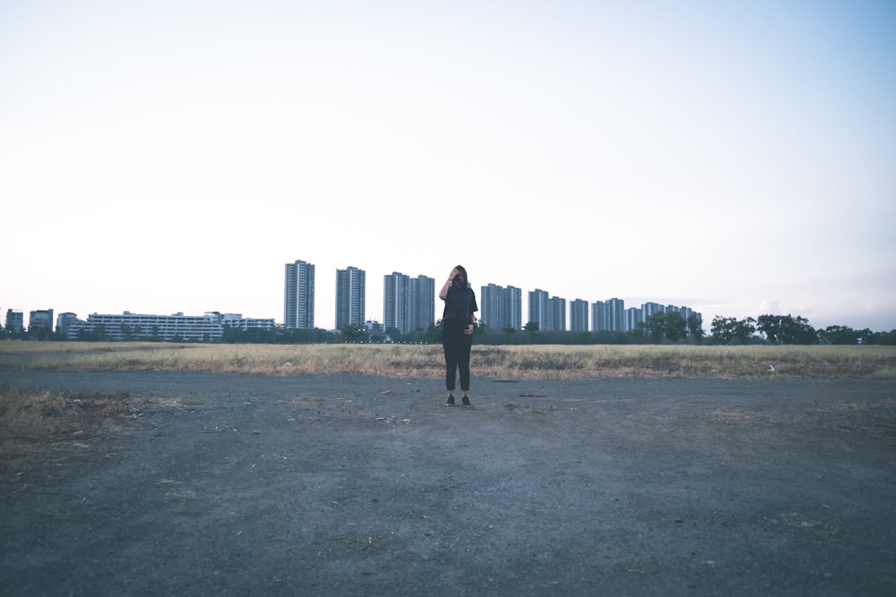 woman wearing black shirt and pants standing on field during daytime