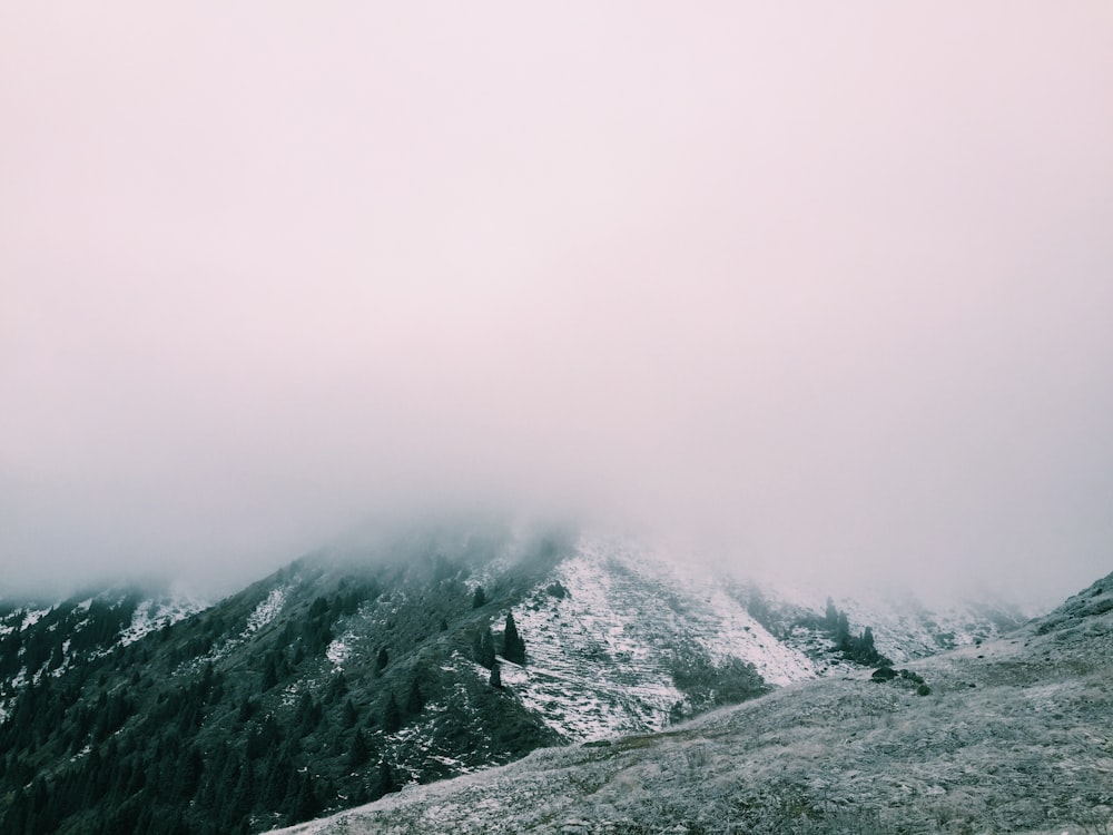 mountain range covered with snow and clouds