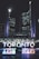 Tall, illuminated skyscrapers tower over a public square at night, with the word 'TORONTO' brightly lit in various colors at the forefront. Reflections of the lights shimmer on a wet surface below.
