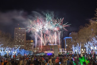A lively crowd celebrating New Year's Eve in Olbia's main square with fireworks overhead