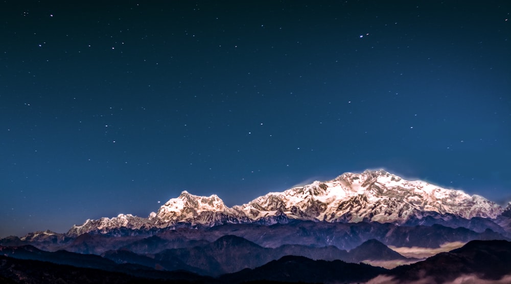 snow covered mountain under starry sky