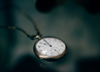 lowlight photography of white pocket watch