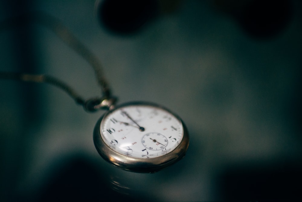 lowlight photography of white pocket watch