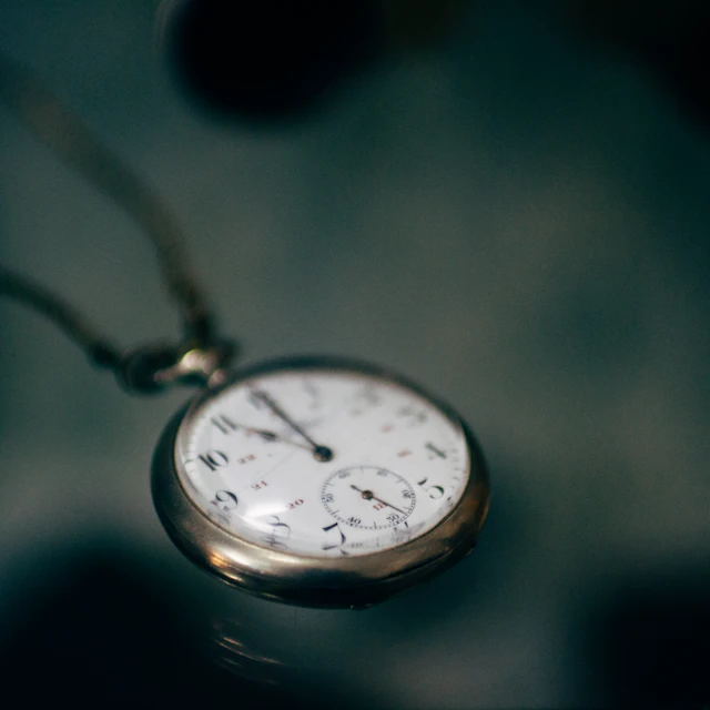 A white pocket watch photographed in low light