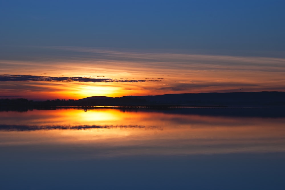 body of water under sunset