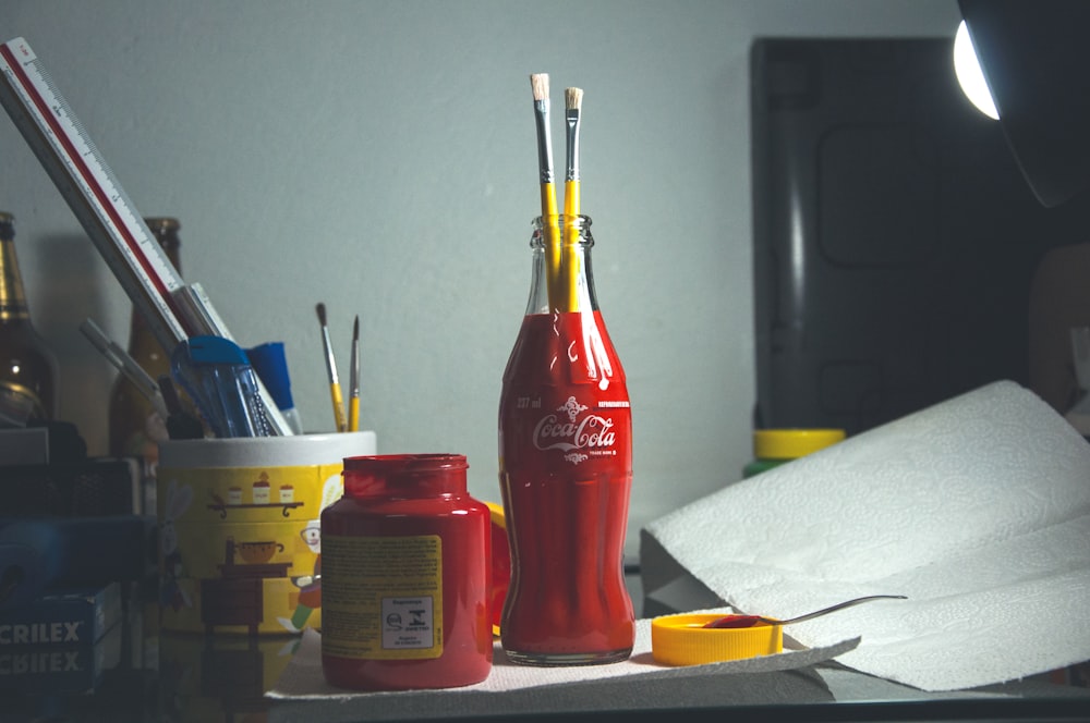 rote Coca-Cola Glasflasche mit Pinseln