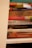 Stack of various books with colorful covers on a cozy shelf.