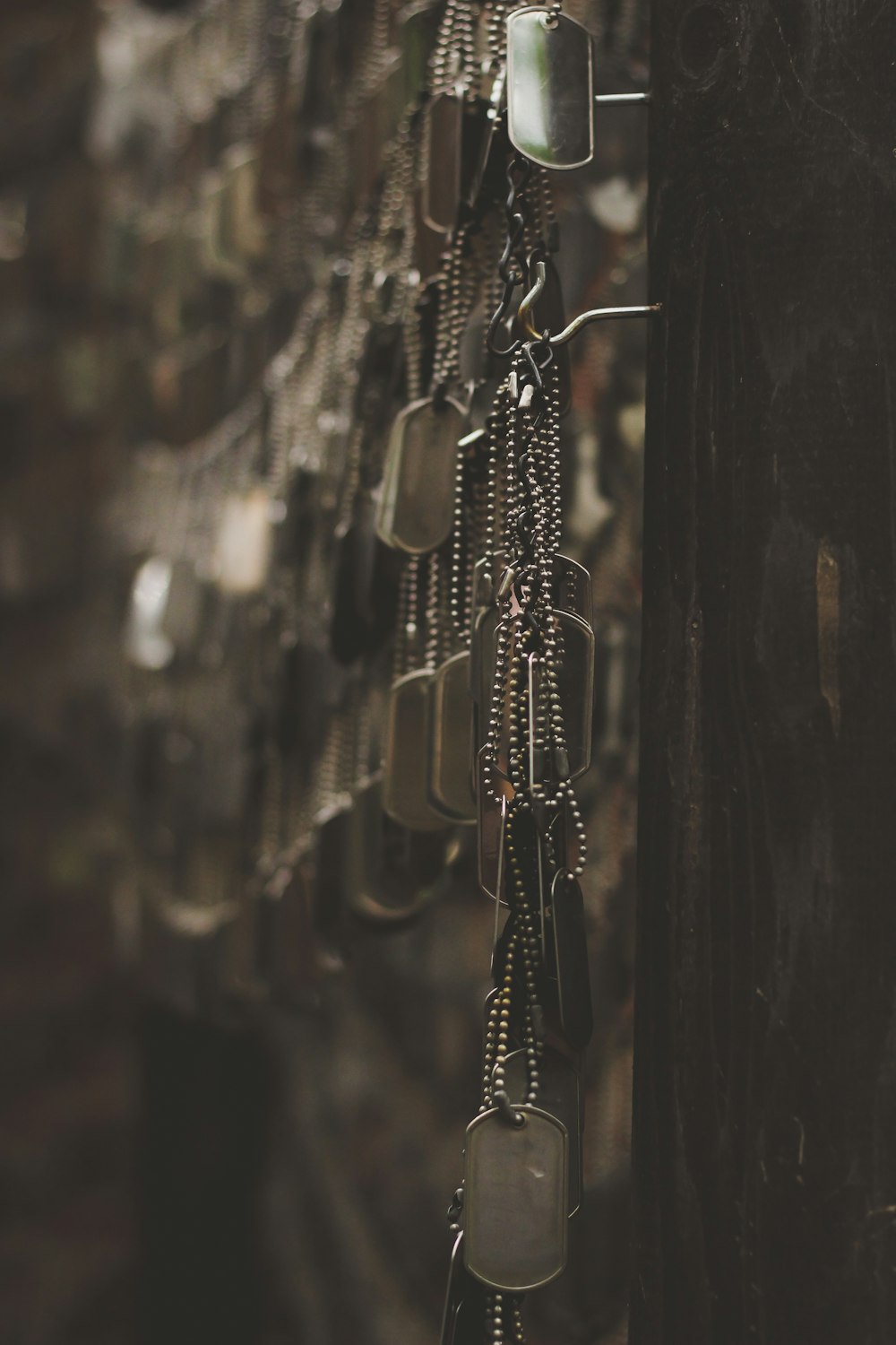 silver-colored god tags hanging on hooks shallow focus photography