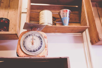Classic analog kitchen scale with a retro design sitting on a wooden countertop.