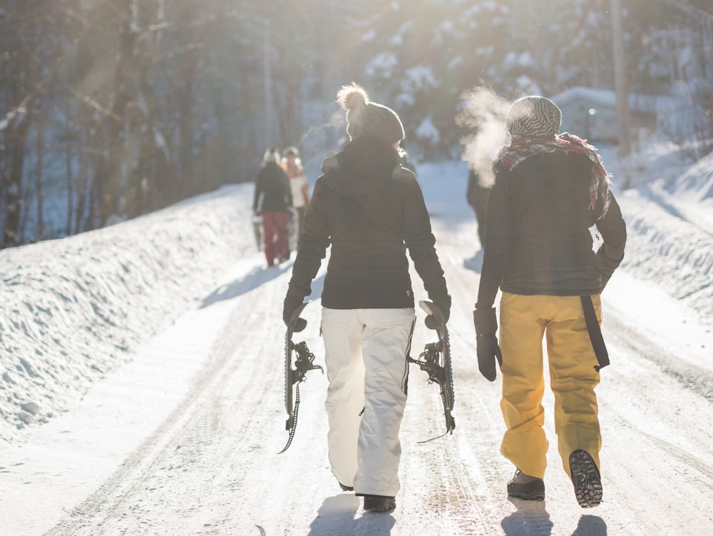 낮에 눈 덮인 산을 걷는 동안 눈 스키 블레이드를 들고 사람