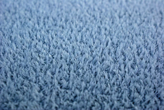 Close-up of a hand feeling the soft texture of a high-quality carpet fiber.