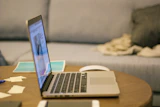 a laptop computer sitting on top of a wooden table