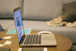 a laptop computer sitting on top of a wooden table