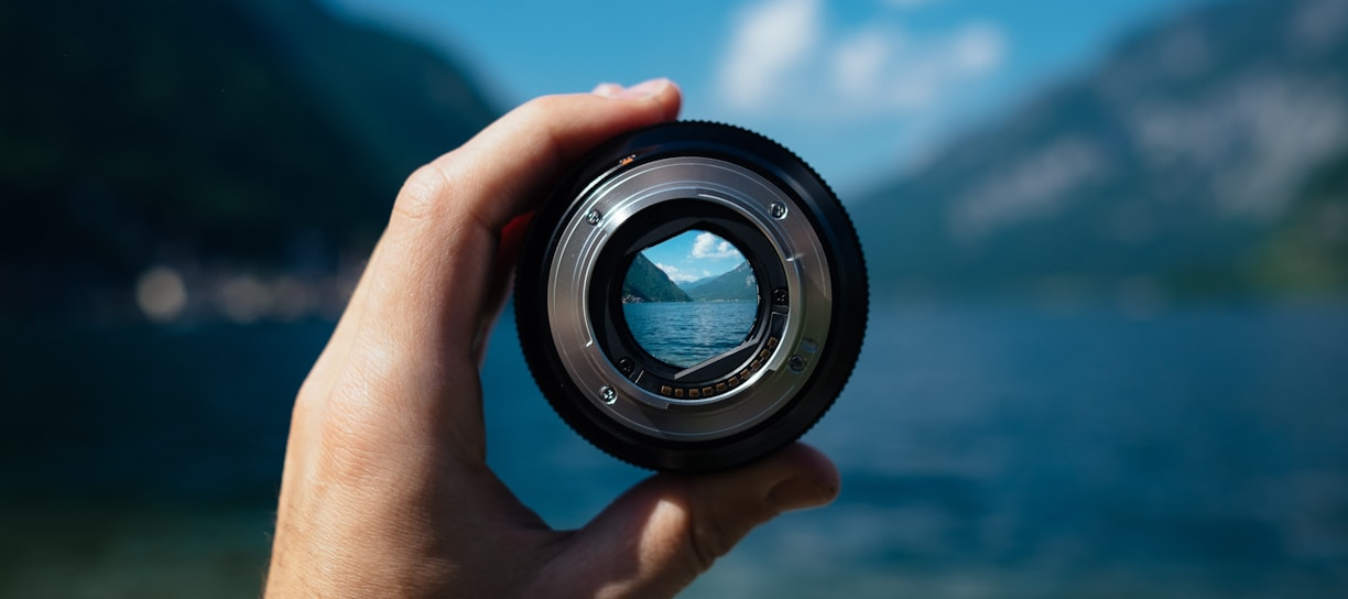 person holding camera lens