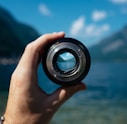 person holding camera lens