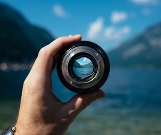 person holding camera lens