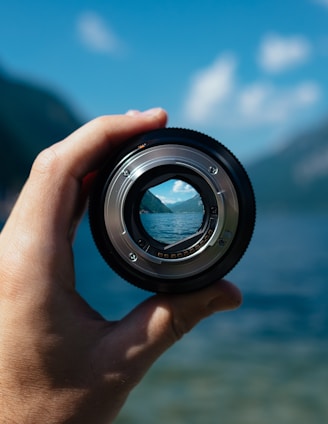 person holding camera lens