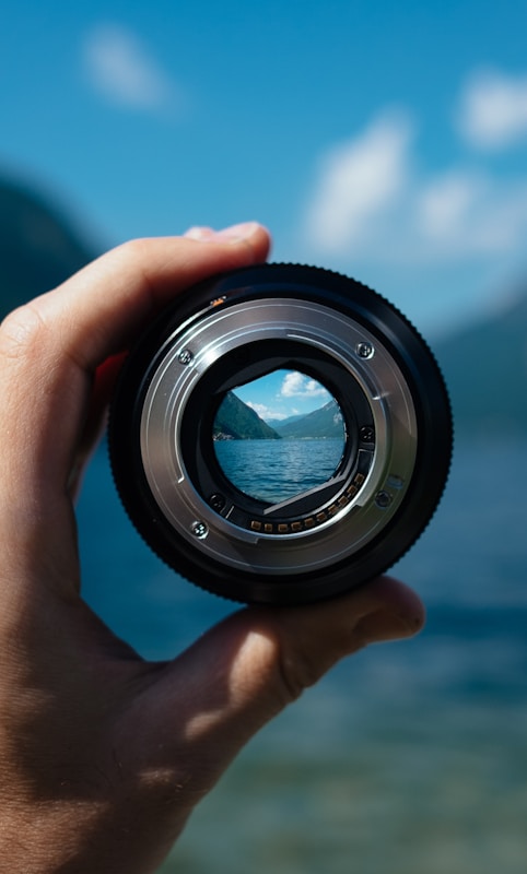 person holding camera lens