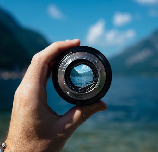 person holding camera lens