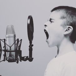 boy singing on microphone with pop filter