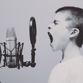 boy singing on microphone with pop filter