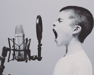 boy singing on microphone with pop filter