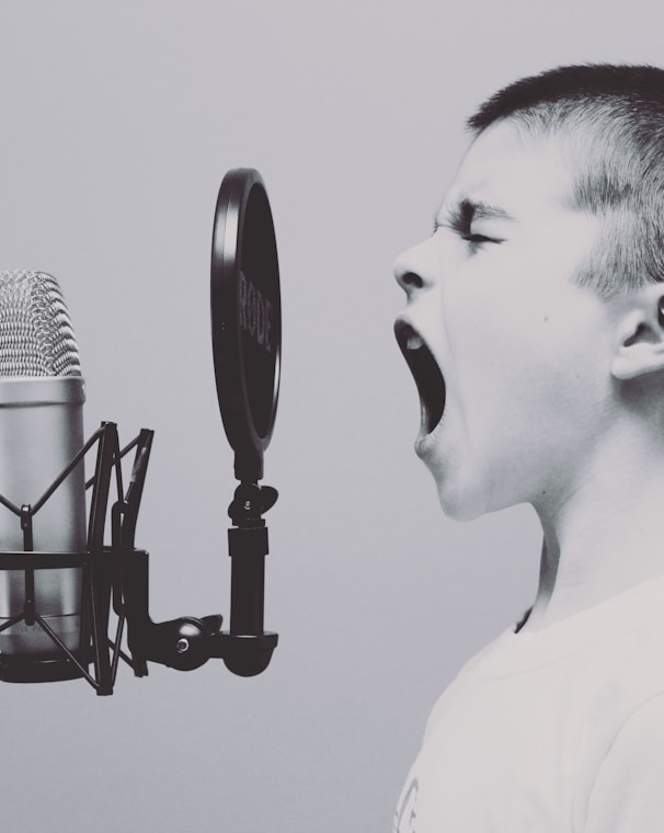 boy singing on microphone with pop filter