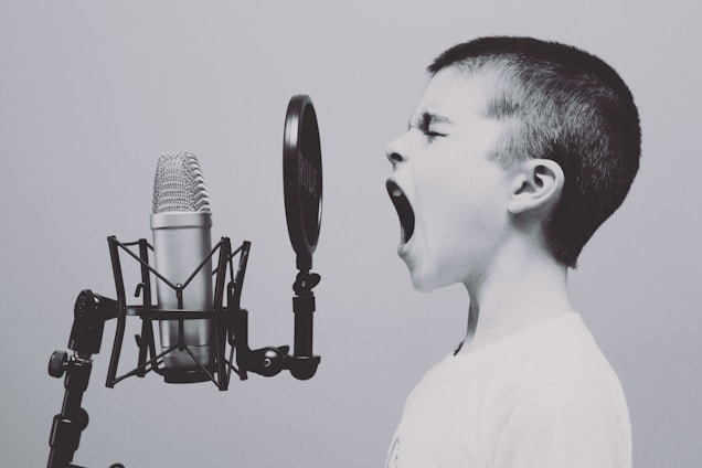 Enfant criant dans un microphone qui va apprendre les 3 règles pour s'exprimer en public