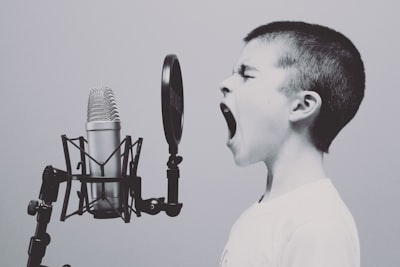 boy singing on microphone with pop filter impossible teams background