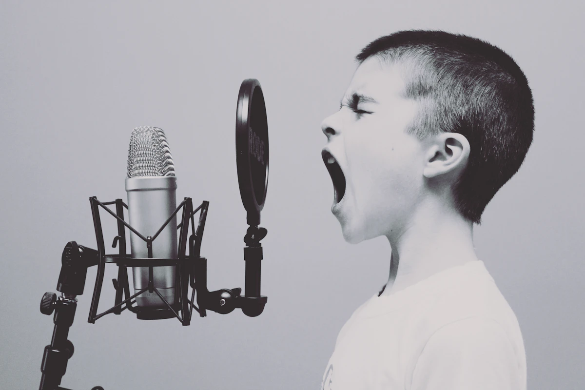 Ba mẹ và bé ngồi cùng nhau đọc sách, hát trong phòng khách