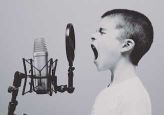 boy singing on microphone with pop filter